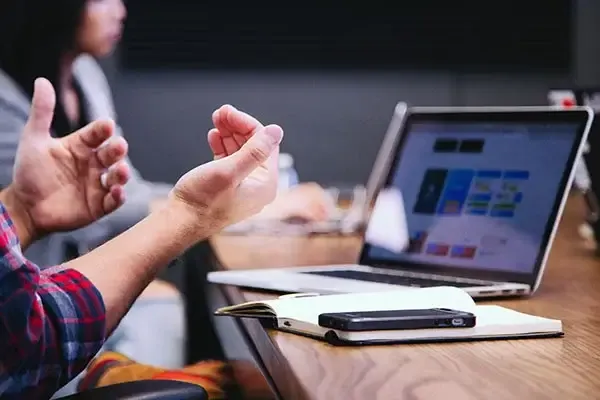 Man presenting over a video call on a laptop