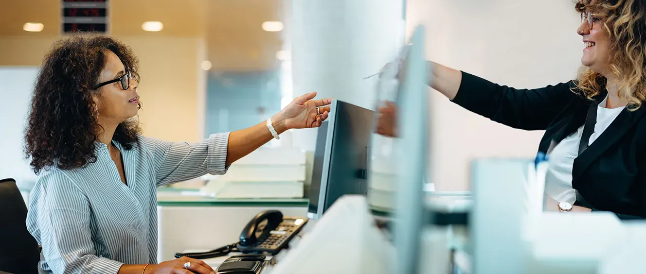 Woman receptionist with glasses being handed something