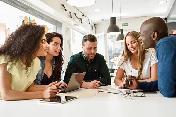 Group of people looking at each other around a table