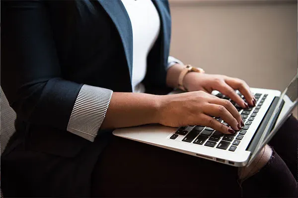 Woman sitting at an office using VoIP on a laptop