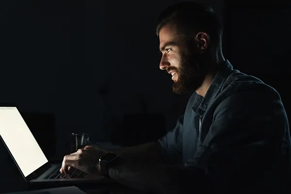 Sideview of man typing on laptop