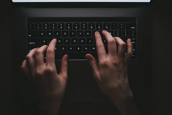 Top-down view of someone typing on laptop