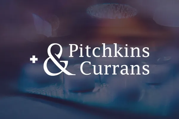 Pitchkins & Currans logo over blurred shot of tablets