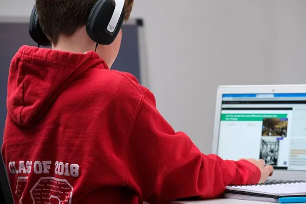 School child typing on laptop