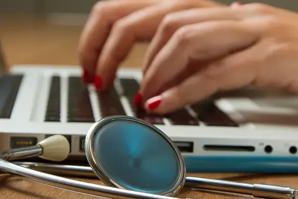 Close up of a woman typing on laptop