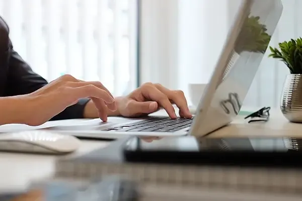 Close up of person using laptop on desk