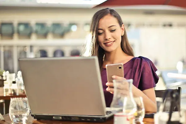 Woman connecting her mobile phone to a laptop