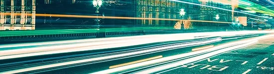 Long exposure shot of cars moving across busy road at night