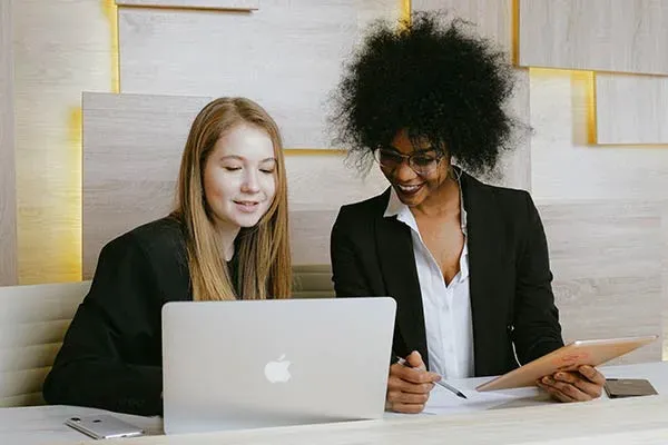 Two Women working at an Apple Mac computer