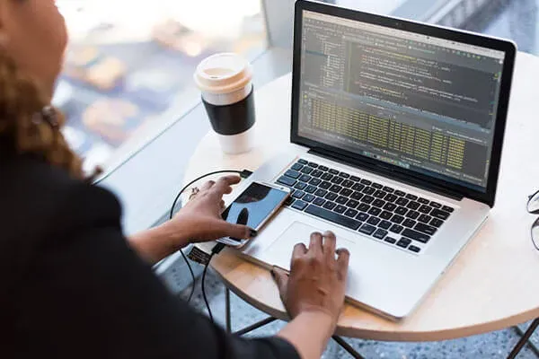 Person about to pick up mobile phone while coding