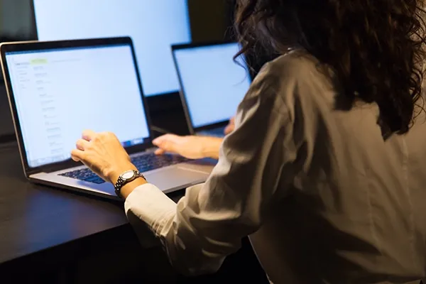 Woman typing on laptop at desk