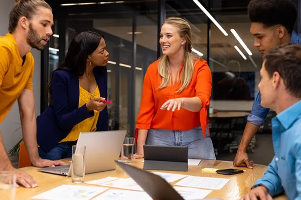 Five people standing around a table while talking