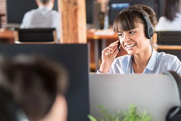 Woman smiling while touching right side of headset microphone